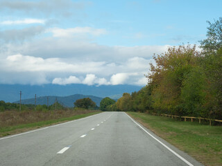 Highway through the autumn forest natural way concept, road to the caucasian forest nature field, relaxing with ecological environment. Mountain Digoria is a national park in North Ossetia