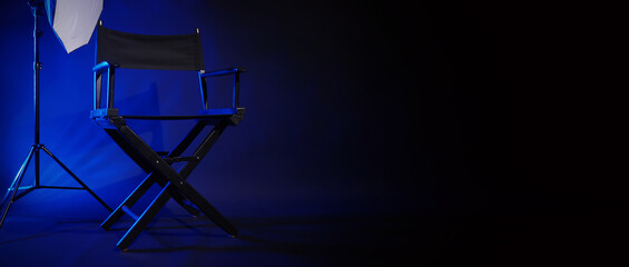 Director chair with cinema lightbox sign Director text on it and clapperboard megaphone and black background studio. Director seat on video production or filming set used in film industry. Real no 3D - obrazy, fototapety, plakaty