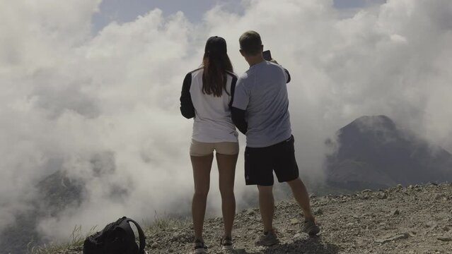 Hiking couple photographing distant volcano in national park / Cerro Verde, Santa Ana, El Salvador