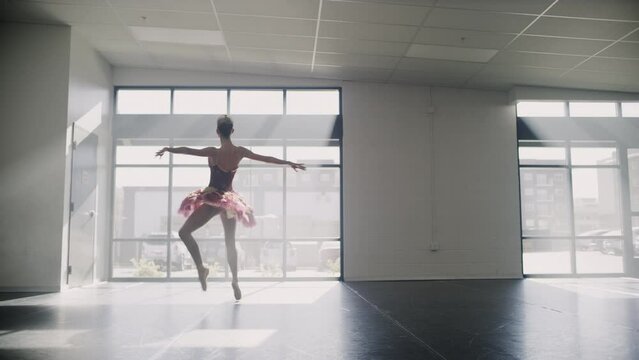 Tracking shot of ballerina practicing spinning in dance studio / Lehi, Utah, United States