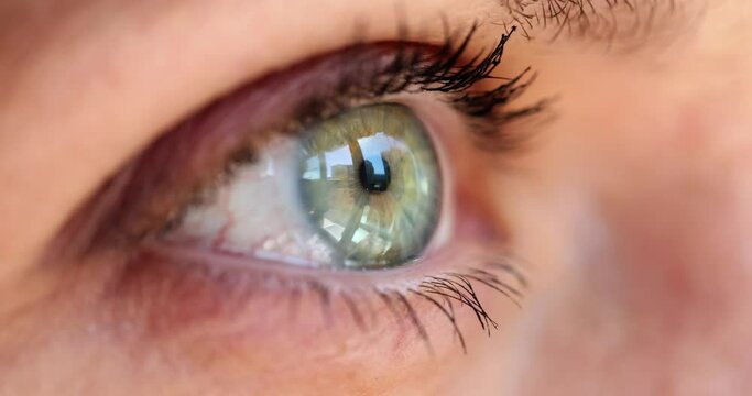 Female gray-green eye looking out window closeup 4k movie slow motion