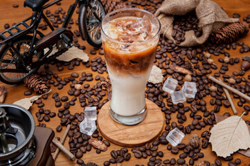 Mrożone cappuccino na stole z kostkami lodu i ziarnami świeżo palonej kawy
