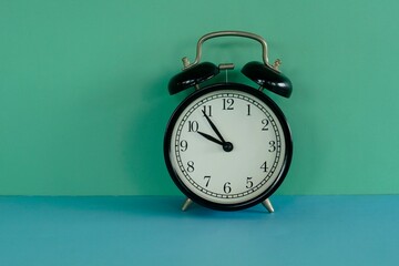 alarm clock against gren background - 551082334