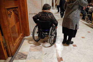 Obraz premium Shallow depth of field (selective focus) details with a woman in a wheelchair during a convention.