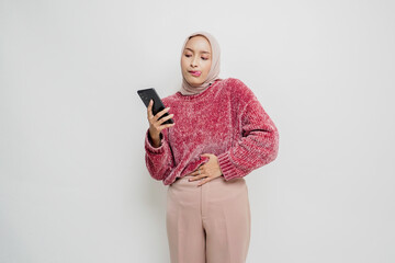 Fototapeta premium Photo of a hungry excited young woman holding her phone and wondering what to order yummy food isolated on white color background