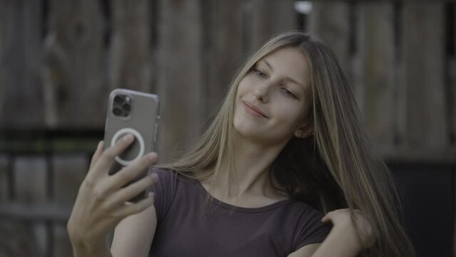 Teenage girl photo bombing friend posing for cell phone selfie / Pleasant Grove, Utah, United States