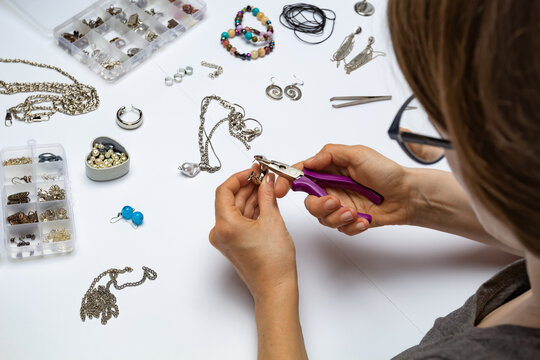 The designer makes handmade jewelry at the workplace.