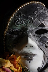Venetian carnival mask with pearls  and dry rose close up on dark background	
