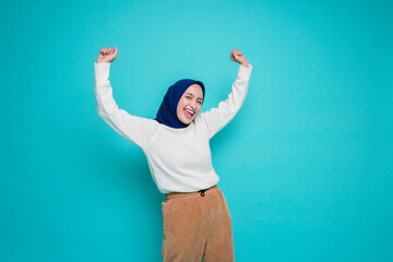 A young Asian Muslim woman with a happy successful expression wearing white shirt and hijab...