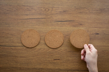 three round cork board and hand selecting the right on wood backdrop