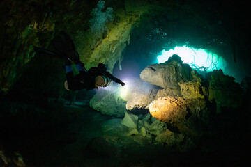 cave diver instructor leading a group of divers in a mexican cenote underwater