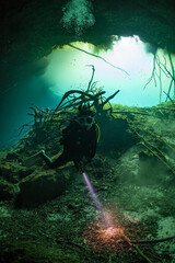 Fototapeta na wymiar cave diver instructor leading a group of divers in a mexican cenote underwater