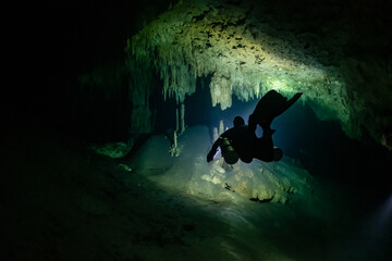 cave diver instructor leading a group of divers in a mexican cenote underwater