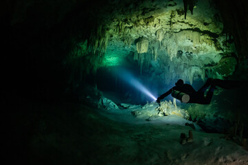 cave diver instructor leading a group of divers in a mexican cenote underwater