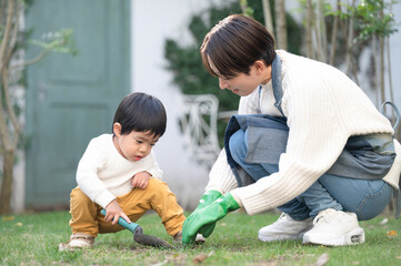 庭で一緒に花壇などを作ろうとする親子