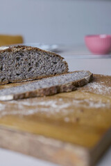 Selective focus on dark rye bread on wooden cutting board breakfast table 