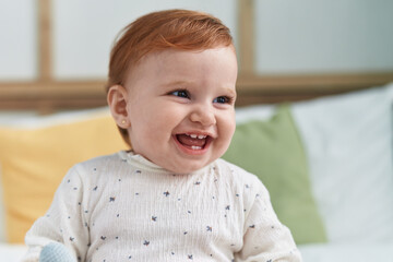 Adorable redhead toddler smiling confident sitting on bed at bedroom