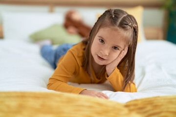 Adorable hispanic girl smiling confident lying on bed at bedroom