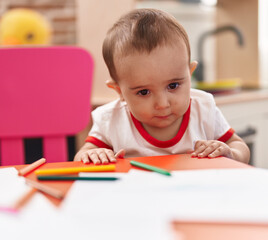 Adorable hispanic baby preschool student holding pencil color standing at kindergarten