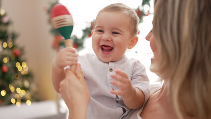 Mother and son playing maraca standing by christmas decoration at kindergarten - Powered by Adobe