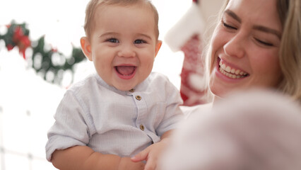 Mother and son smiling confident standing by christmas decoration at home