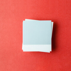 The Blank paper note for your text or message on red background, top view.