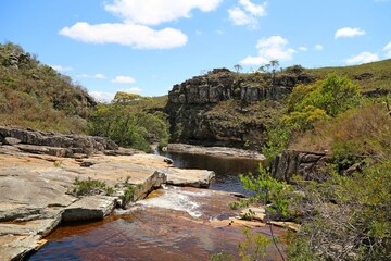 Creek flowing over rocks in small canyon with vegetation and rocks. Region of Conceiçao de Mato Dentro in Minas Gerais, Brazil