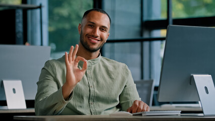 30s happy satisfied glad African businessman manager office worker boss male company CEO man employer entrepreneur working with computer online showing ok sign okay good approval gesture agree zero - obrazy, fototapety, plakaty