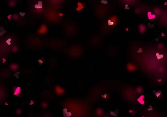 Glowing blurred hearts on dark background.Valentine's day backdrop. Romantic holiday texture.