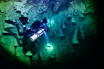 cave diver instructor leading a group of divers in a mexican cenote underwater