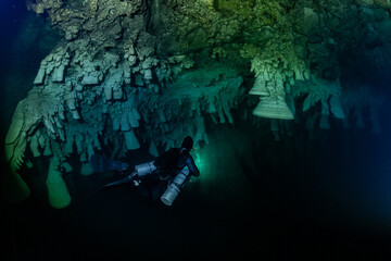 cave diver instructor leading a group of divers in a mexican cenote underwater