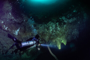 cave diver instructor leading a group of divers in a mexican cenote underwater