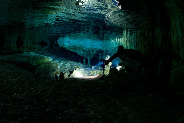 cave diver instructor leading a group of divers in a mexican cenote underwater