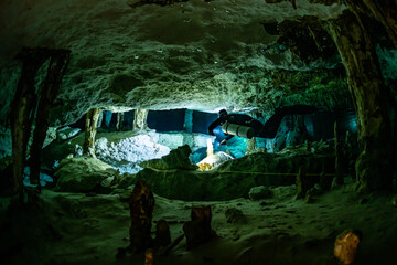cave diver instructor leading a group of divers in a mexican cenote underwater