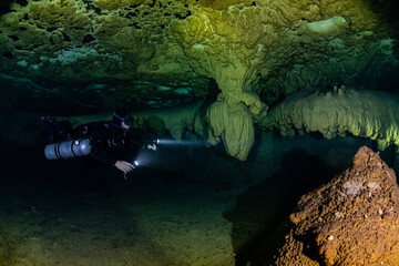 cave diver instructor leading a group of divers in a mexican cenote underwater