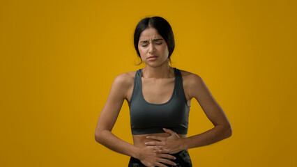 Sick ill Indian woman suffering from stomach ache holding belly feeling abdominal menstrual pain...