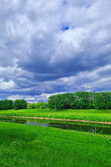 Gloomy sky before a thunderstorm on the river bank.