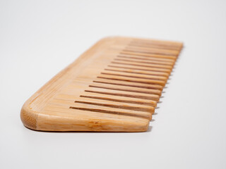 Wooden comb for hair on a white background.