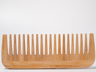 Wooden comb for hair on a white background.