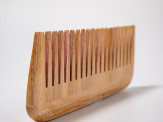 Wooden comb for hair on a white background.