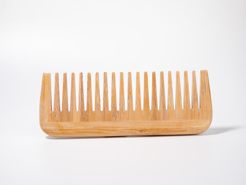 Wooden comb for hair on a white background.