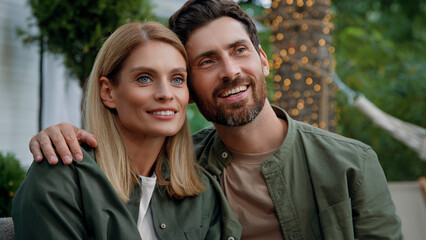 Loving married couple husband and wife Caucasian bearded man and blonde woman 40s spouses sit outdoors looking into distance dreaming contemplating thinking about future talking conversation cuddling