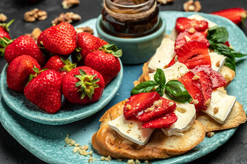 Toasts or bruschetta with trawberries, cheese camembert nuts and honey. Summer breakfast. Healthy, clean eating. Vegan or gluten free diet