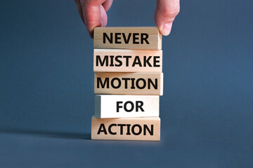 Mistake or action symbol. Concept words Never mistake motion for action on wooden blocks. Businessman hand. Beautiful grey table grey background. Business mistake or action concept. Copy space.