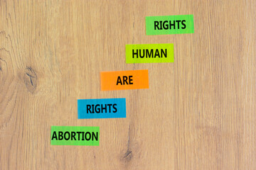 Abortion rights symbol. Concept words Abortion rights are human rights on colored paper. Beautiful wooden table wooden background. Business medical abortion rights concept. Copy space.