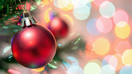 Christmas decoration. Red balls hanging on pine branches Christmas tree garland and ornaments over abstract bokeh background with copy space