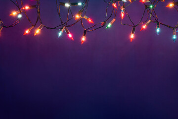 Christmas lights string on blue background with copy space