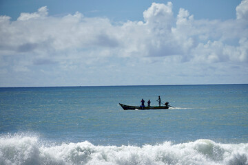 Fototapeta na wymiar Indian fishermen sailing in fishing boat at Mahabalipuram beach, Tamilnadu.