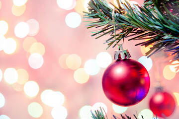 Christmas decoration. Red balls hanging on pine branches Christmas tree garland and ornaments over abstract bokeh background with copy space