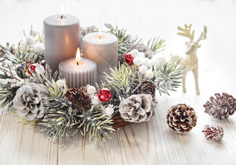 Fototapeta na wymiar Decorated Advent wreath from fir and evergreen branches with burning candles, tradition in the time before Christmas.